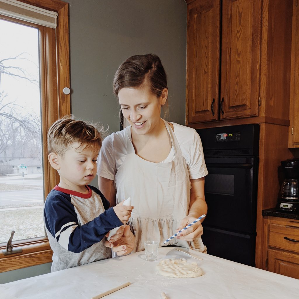 Mom and toddler in kitchen making craft together by Abbie Ulstad
